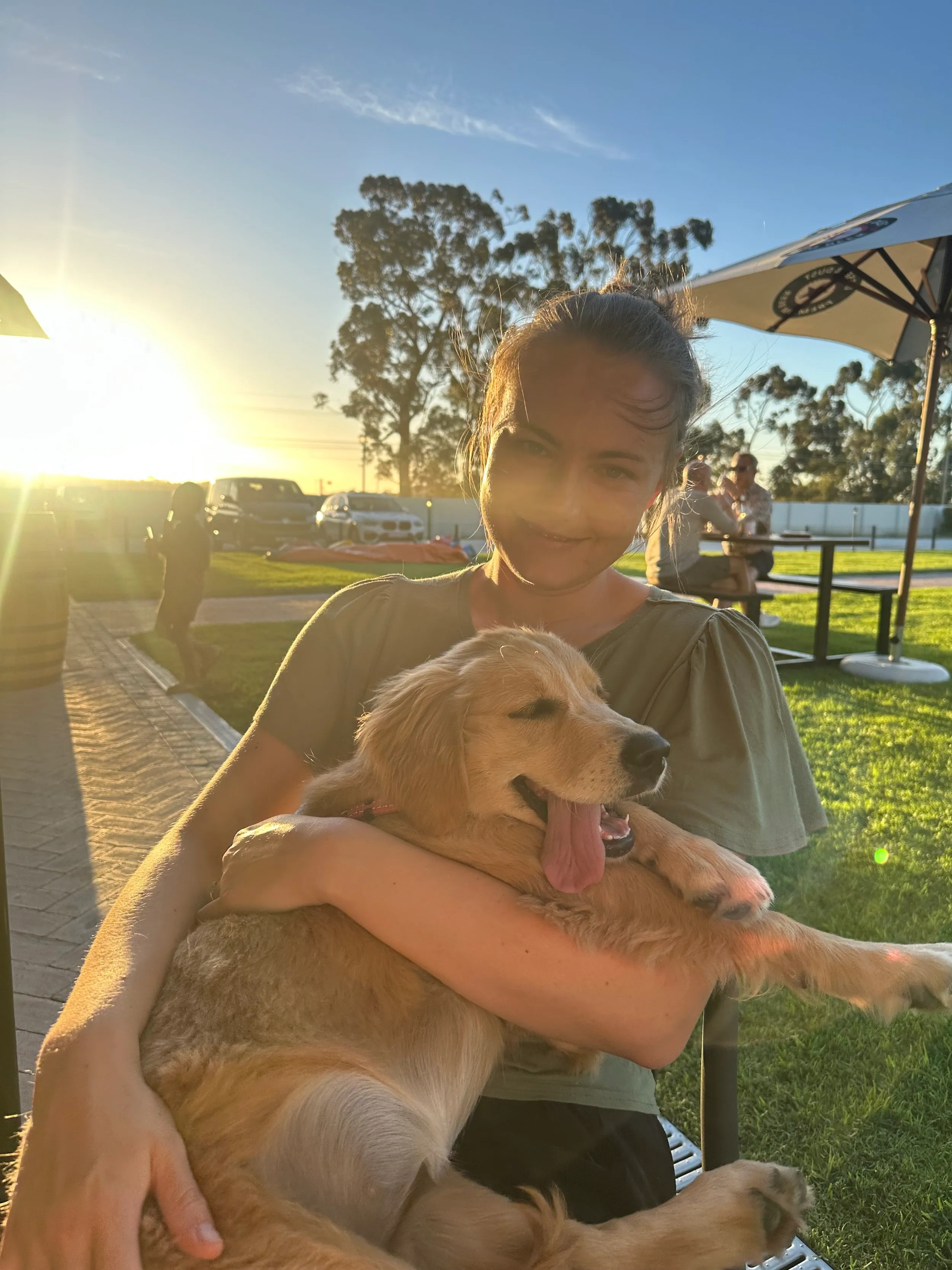 Christie Lamprecht holding a golden retriever puppy outdoors